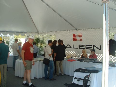 1999 Ford Crown Victoria - Attendees browse tables under a tent at a car show, with a prominent SALEEN banner displayed.