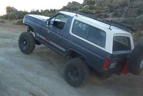1986 Ford Bronco - This modified SUV is shown navigating a rocky, off-road terrain with its large tires providing traction.