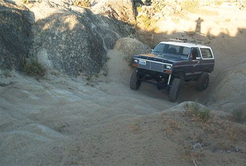 1986 Ford Bronco - This Ford Bronco navigates a challenging sandy terrain, its off-road capabilities.