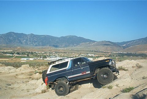 1986 Ford Bronco - This 1986 Ford Bronco is navigating a rocky, off-road terrain under a clear blue sky.