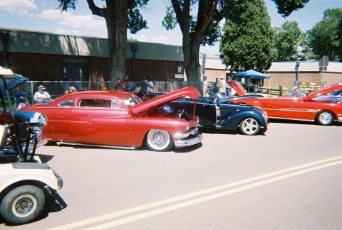 1972 Ford Ranchero - A line of classic cars, including a red 1950 Mercury coupe, are displayed at an outdoor event.