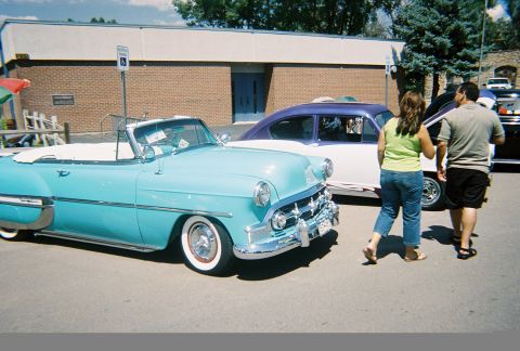 1972 Ford Ranchero - A classic light blue convertible is on display at an outdoor event, with a two-tone sedan behind it.