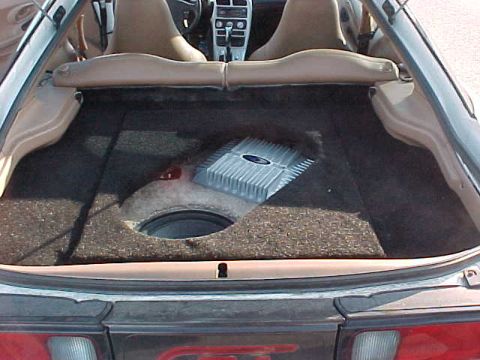 1993 Ford Probe - Trunk interior with aftermarket audio equipment, including a subwoofer and amplifier.