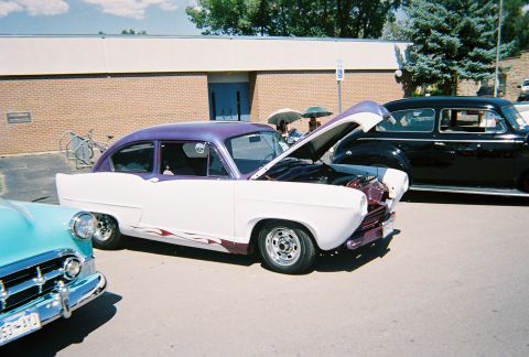 1972 Ford Ranchero - A custom two-tone car with flame decals is displayed with its hood up at an outdoor event.