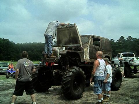 1987 Suzuki Samurai - Several people gather around a heavily modified Jeep CJ at an outdoor event.