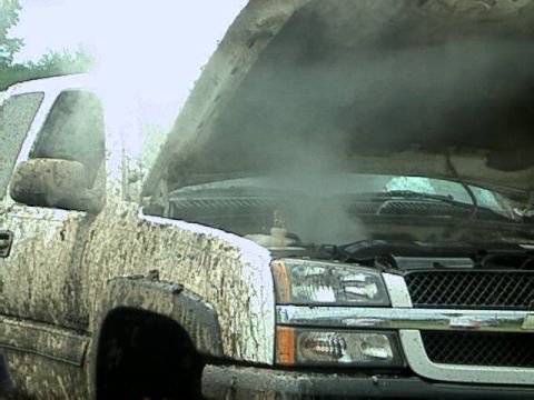 1987 Suzuki Samurai - This truck appears to be overheating, with steam escaping from under the open hood after being covered in mud.