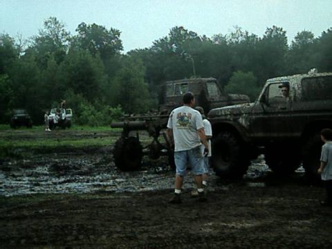 1987 Suzuki Samurai - Several off-road vehicles are stuck in the mud during an outdoor event.