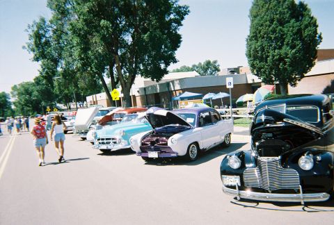 1972 Ford Ranchero - Classic cars are displayed at an outdoor event, with attendees observing the vehicles.