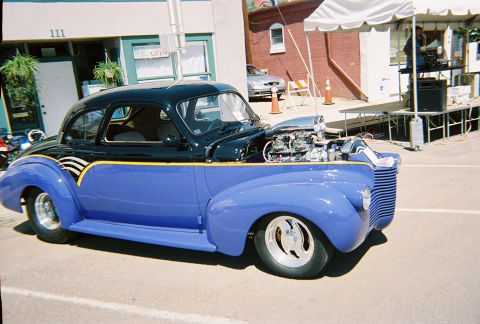 1972 Ford Ranchero - A customized coupe with a prominent engine and unique paint scheme is displayed outdoors.