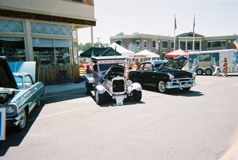 1972 Ford Ranchero - A black coupe from the 1950s is displayed with its hood open at an outdoor car show.
