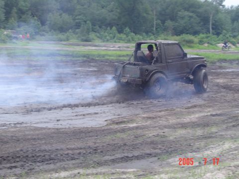 1995 Dodge 1500 - An off-road vehicle navigates a muddy track, generating a cloud of smoke.