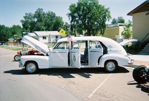 1972 Ford Ranchero - A white limousine with all doors open and hood up, parked on a street with another vehicle visible.