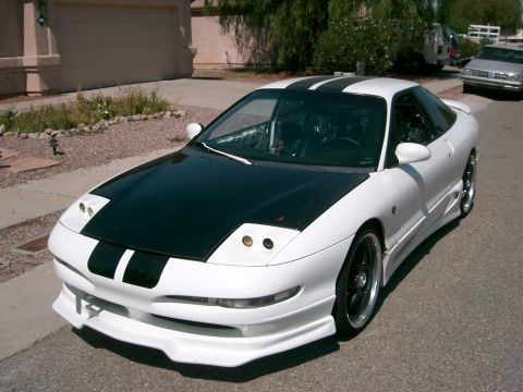 1996 Ford Probe - A modified 1996 Ford Probe with a custom body kit and racing stripes is parked on a residential street.