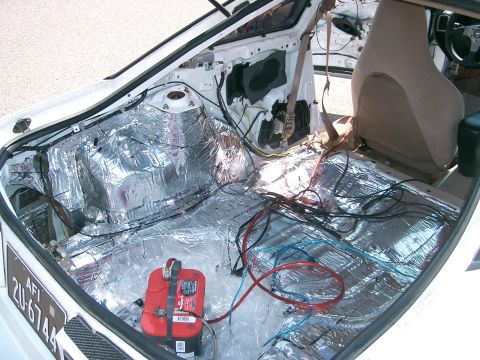 1996 Ford Probe - Interior of a car undergoing sound deadening and wiring installation, with the battery and various cables exposed.