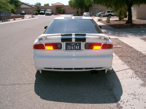 1996 Ford Probe - White 1996 Ford Probe with black racing stripes parked on a residential street.