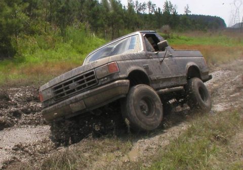 1988 Ford Bronco - Ford Bronco navigating a challenging muddy terrain.