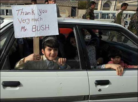 1983 Ford F-250 - Children hold a sign from inside a white car, with people and buildings visible in the background.