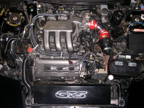 1997 Ford Probe - Close-up view of a modified V6 engine bay with aftermarket parts and a GTS engine cover.