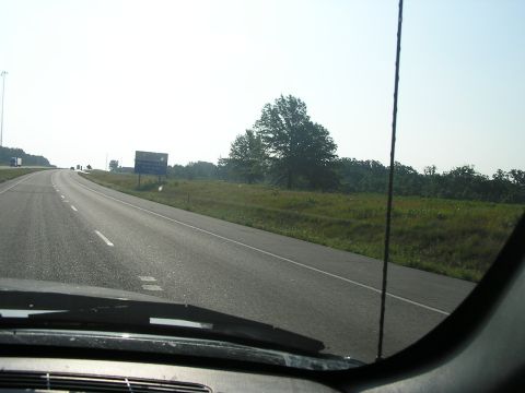 1993 Ford Taurus - Driving on a highway with grassy fields and trees lining the road.