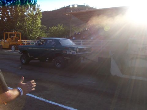 1994 Ford F-150 - A modified sedan with a lifted suspension participates in a pull event on a dirt track.