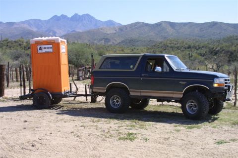 1994 Ford Bronco - Ford Bronco tows a portable toilet through a dry, mountainous terrain.