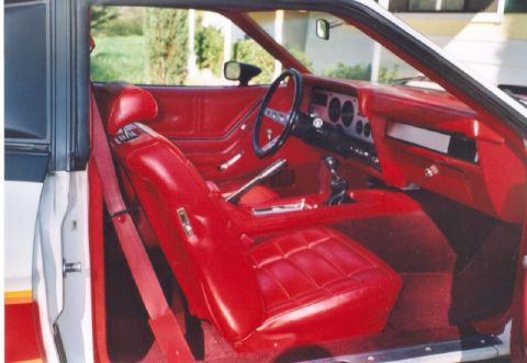 1978 Ford Mustang II - The interior of a 1978 Ford Mustang II features red vinyl seats and matching door panels.