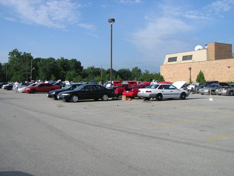 1993 Ford Taurus - A gathering of vehicles in a parking lot on a sunny day.