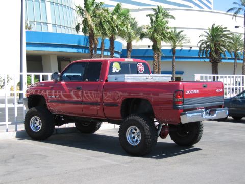 2003 BMW Z4 - This lifted red Dodge Ram pickup truck features a toolbox and custom decals on the rear window.