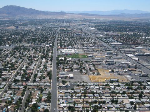 2003 BMW Z4 - An aerial perspective captures a vast urban landscape stretching towards distant mountains under a clear sky.