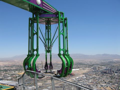 2003 BMW Z4 - A large amusement ride structure is seen suspended high above a city, with mountains in the background.