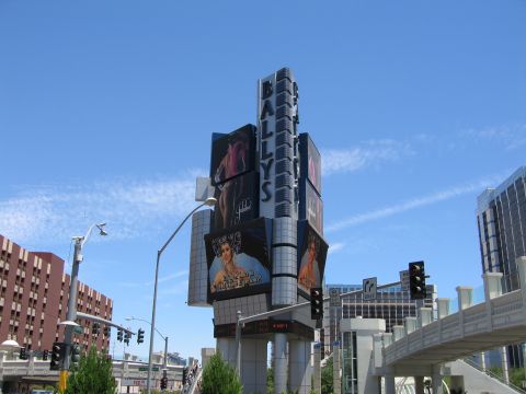 2003 BMW Z4 - The iconic Bally's Las Vegas sign stands tall against a bright blue sky, displaying digital advertisements.