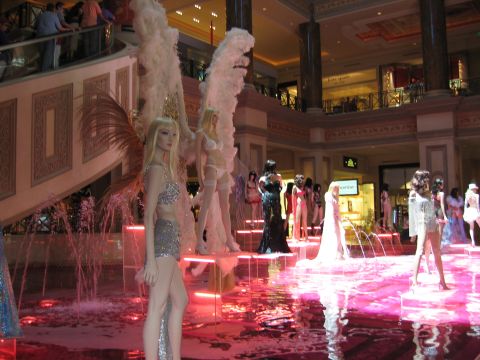 2003 BMW Z4 - Mannequins are displayed around a pink fountain in a shopping mall, with people watching from an upper level.