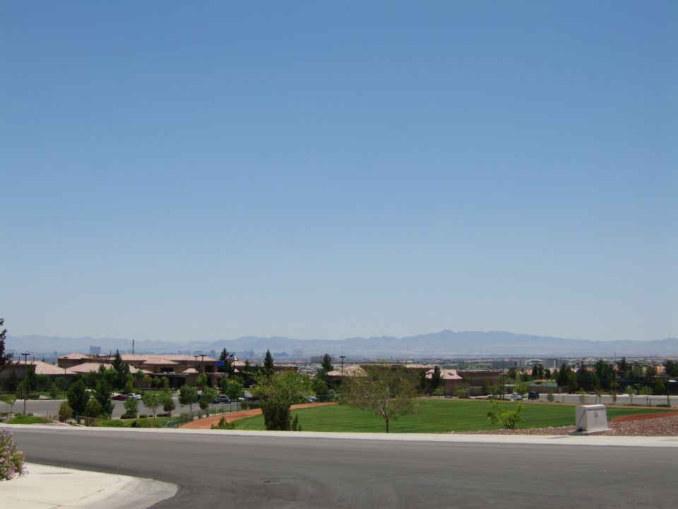 Suburban landscape with distant mountains and a road in the foreground