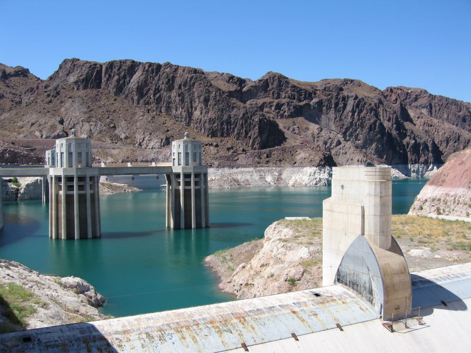 Hoover Dam with intake towers in turquoise water under a clear blue sky
