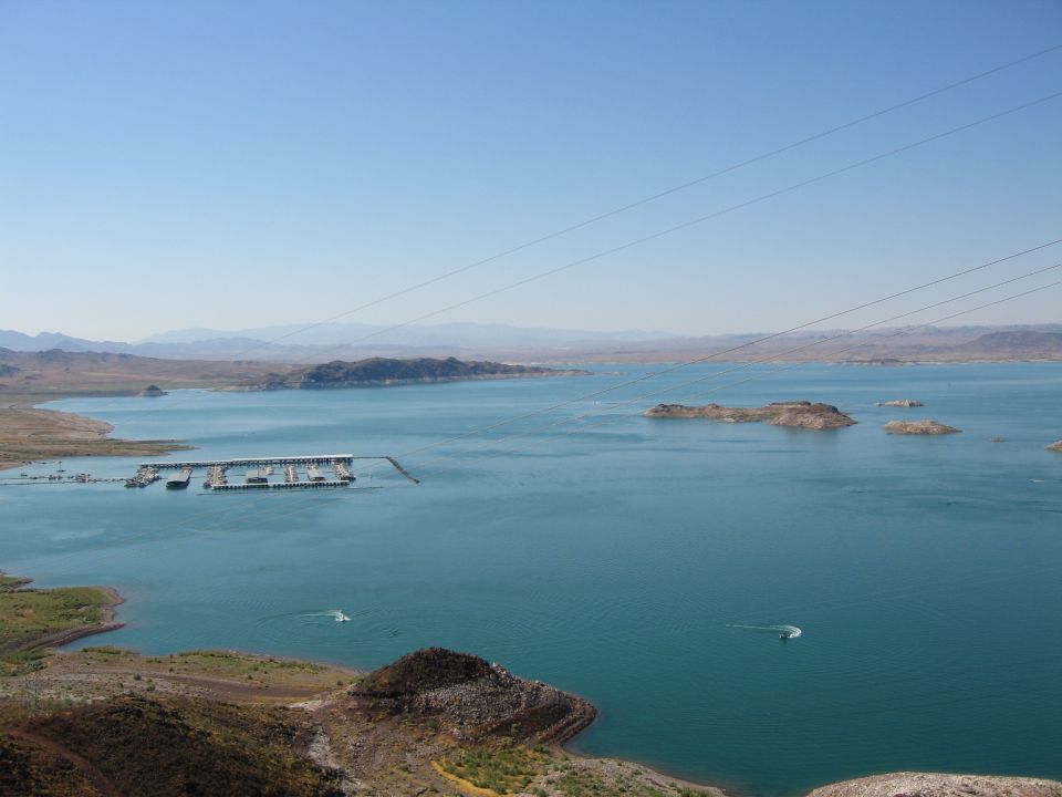 wide view of a large lake with a floating dock and a few boats on the water