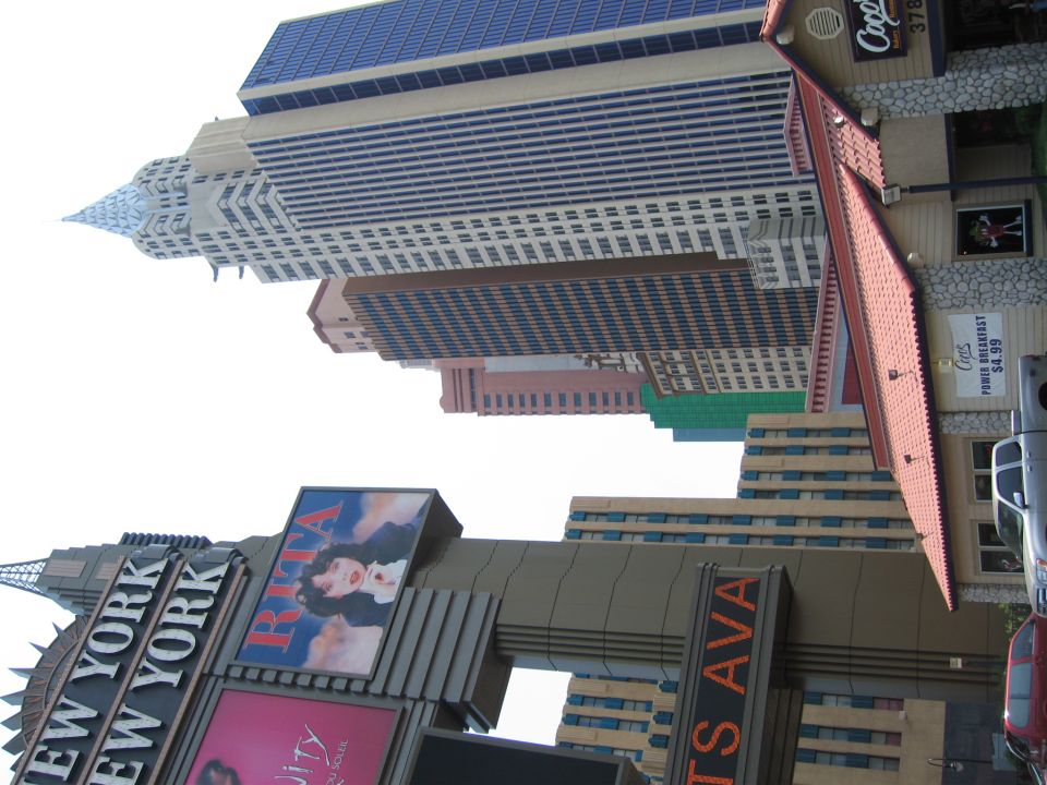 New York City skyline with buildings and signs, including 'New York New York' and 'Rita'