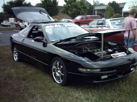 1995 Ford Probe - A black 1995 Ford Probe is displayed with its hood and trunk open at an outdoor event.
