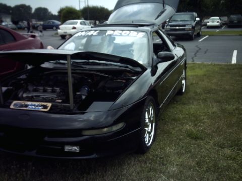 1995 Ford Probe - A black 1995 Ford Probe is displayed with its hood and trunk open at an outdoor event.