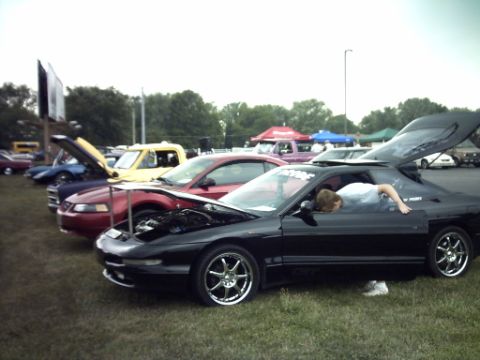 1995 Ford Probe - Cars are displayed with their hoods and trunks open at an outdoor event.