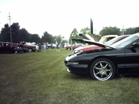 1995 Ford Probe - A black 1995 Ford Probe is displayed with its hood open at an outdoor car show event.
