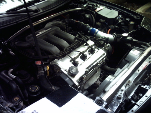 car engine bay with intake and valve cover visible