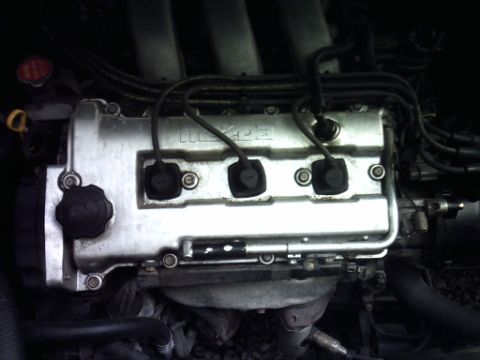 1995 Ford Probe - Close-up view of a Mazda engine, highlighting the valve cover and associated wiring.