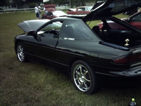 1995 Ford Probe - 1995 Ford Probe shown with hood and trunk open at an outdoor gathering.