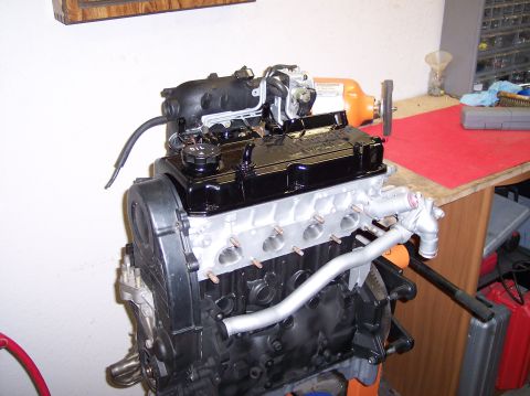 1999 Mitsubishi Mirage - Engine assembly on a stand in a workshop setting, with tools and equipment visible in the background.