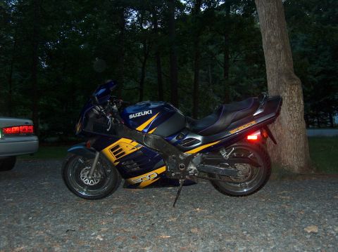 2002 Suzuki TL1000R - Side view of a blue and yellow 2002 Suzuki TL1000R motorcycle parked outdoors.