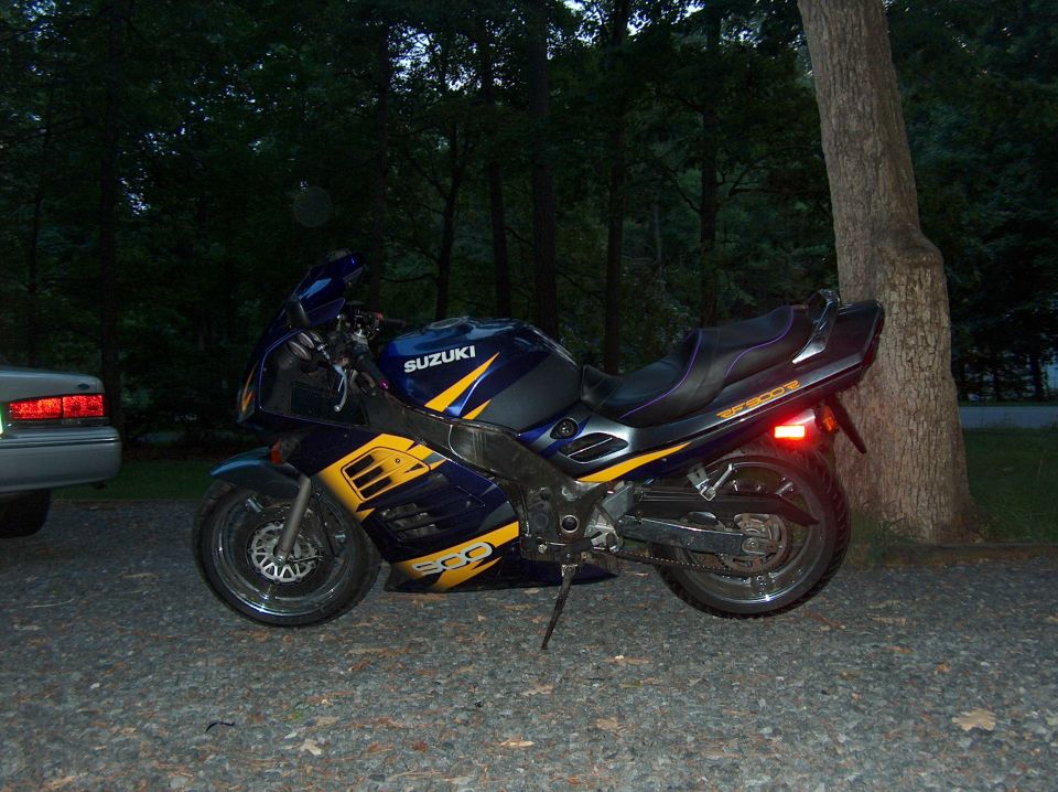 2002 Suzuki TL1000R motorcycle, blue and yellow, parked on gravel near a tree