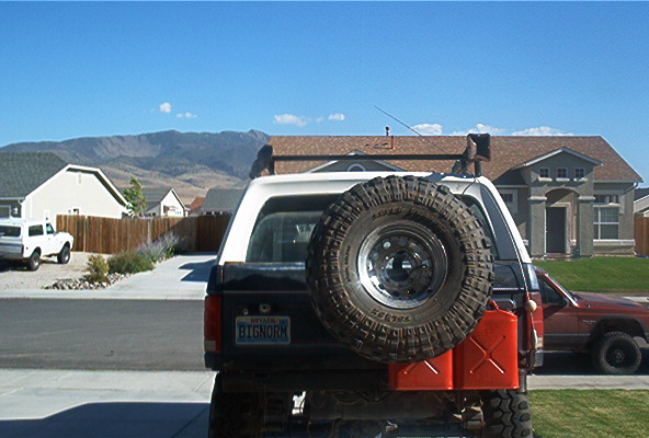 Rear of a black 1987 Ford Bronco with spare tire and jerrycans