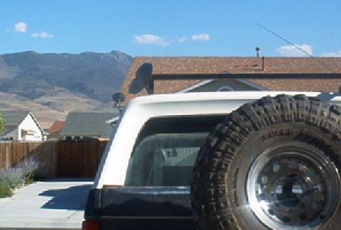 1986 Ford Bronco - Rear view of a 1986 Ford Bronco, showing the spare tire carrier and white hardtop.