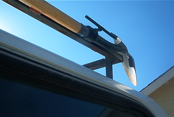 Roof rack holding a pickaxe against a blue sky