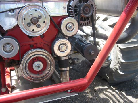 1993 Ford Taurus - The intricate belt system on a red engine block is shown in detail.